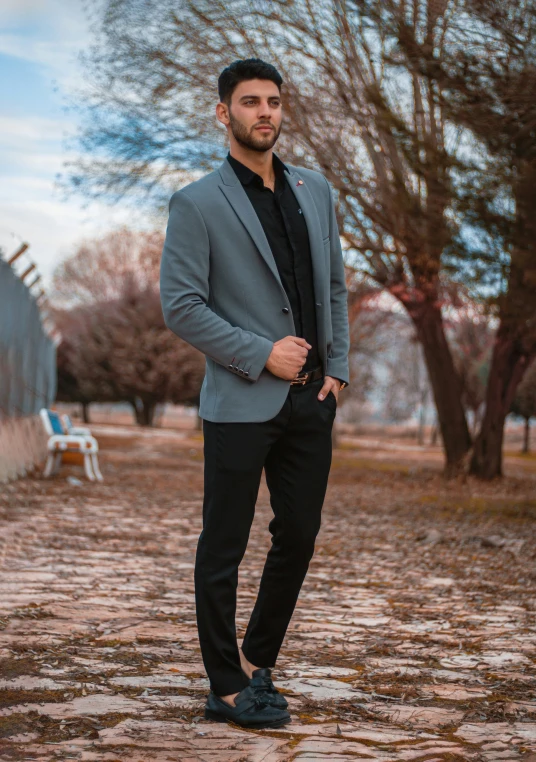 a man is standing on a sidewalk wearing a jacket