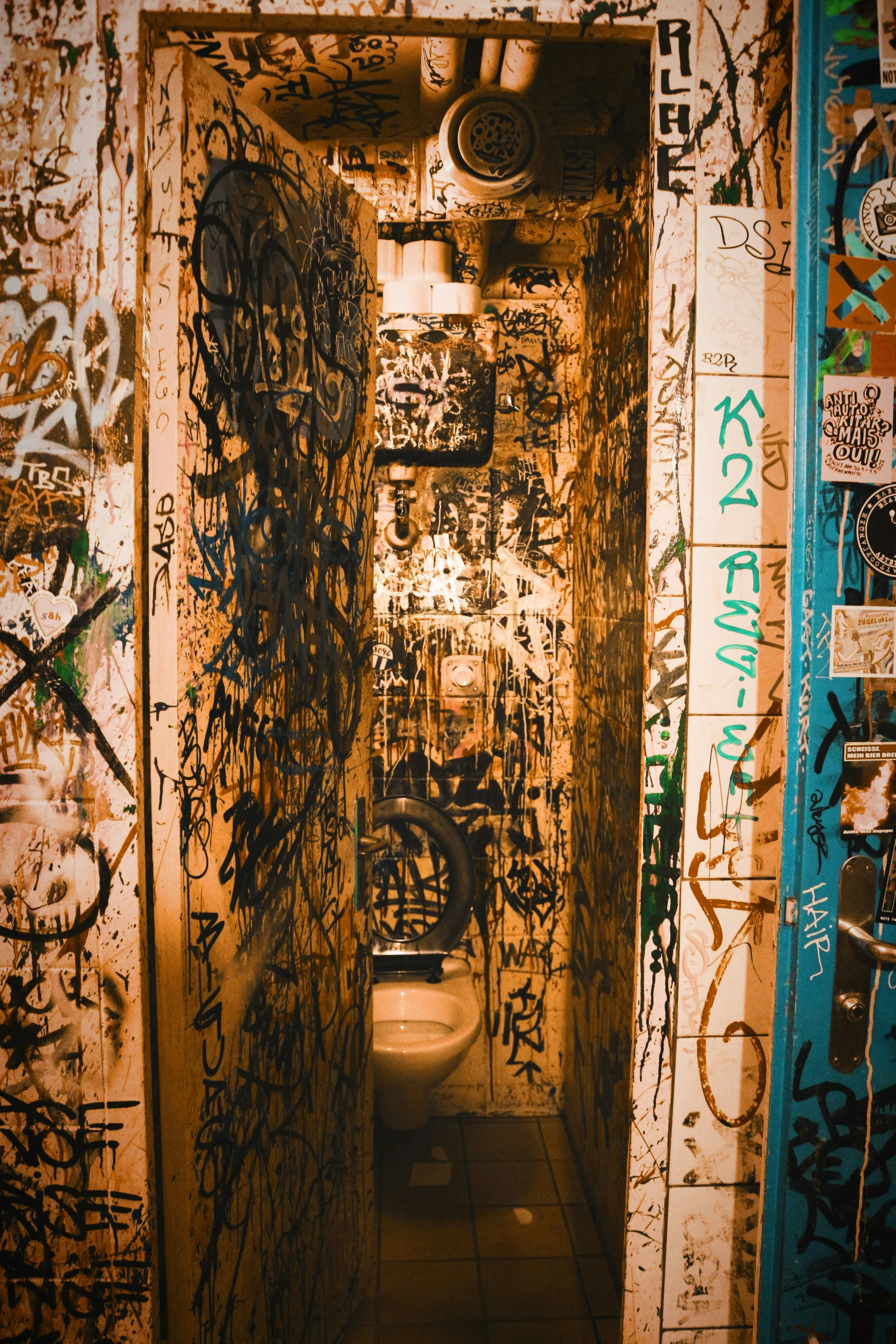 a tunnel is covered with graffiti and lit from the bottom