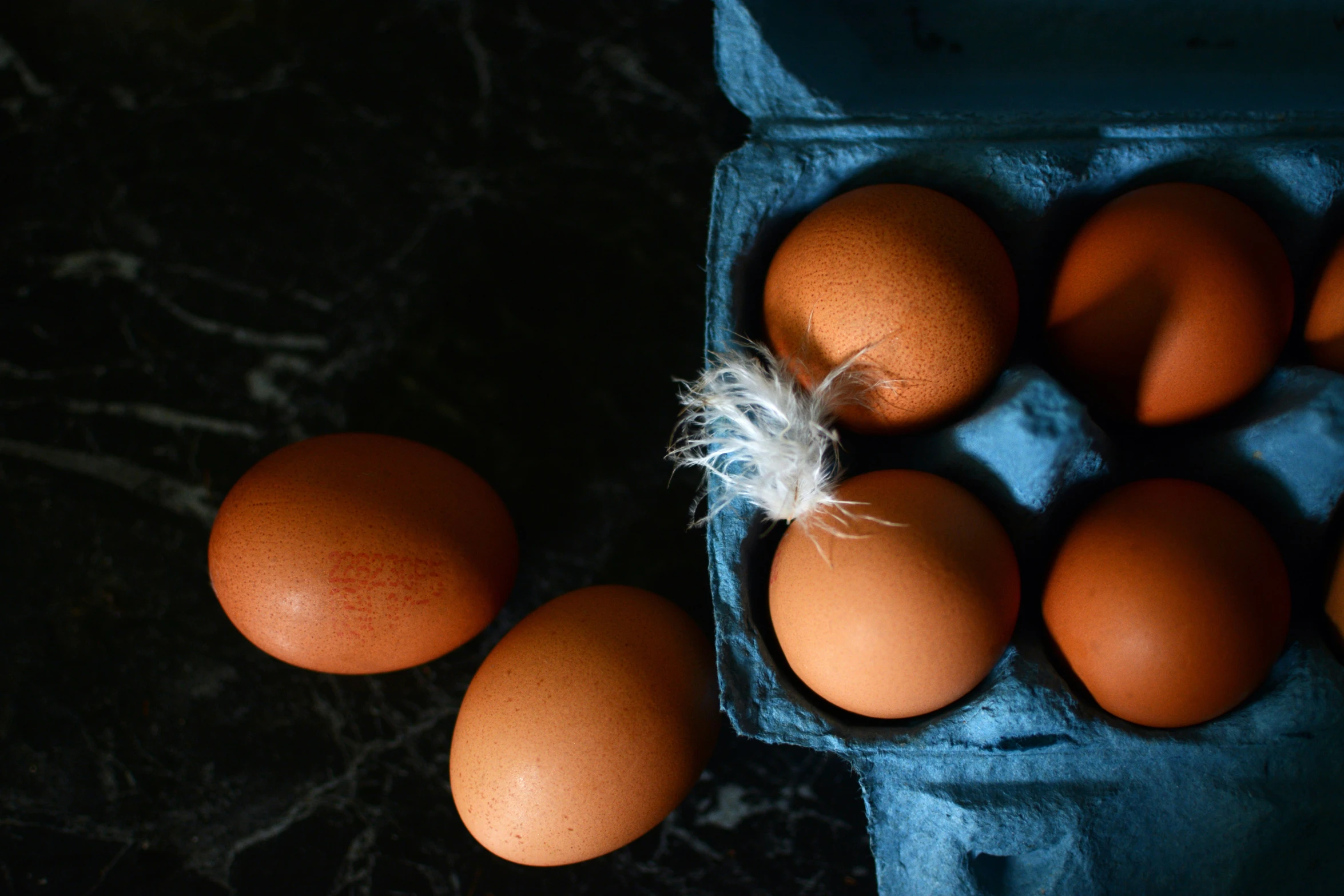 eggs inside a cardboard box are one and two on the floor