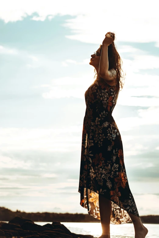 a woman with long hair is in an open dress looking into the sky