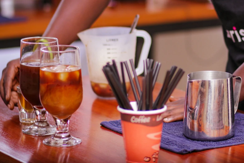 two people holding glasses filled with drinks