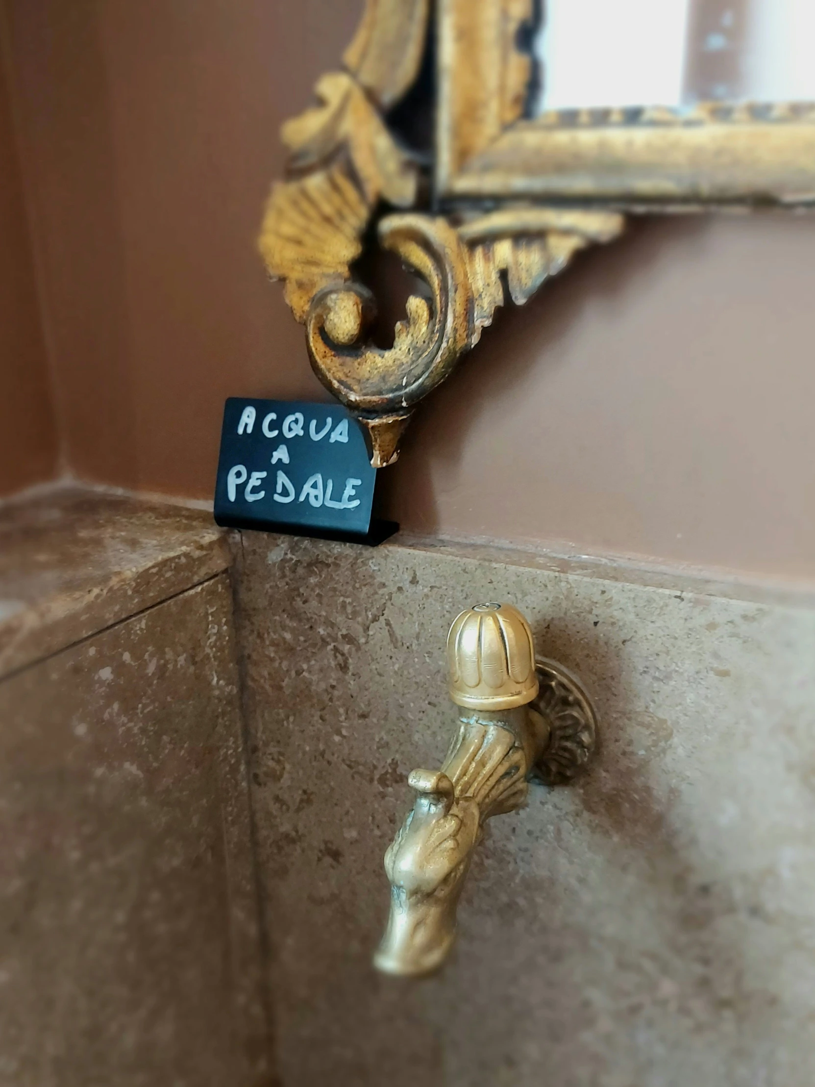 a faucet in front of a mirror that reads moque per paquet