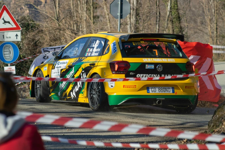 a yellow and green car driving down the street