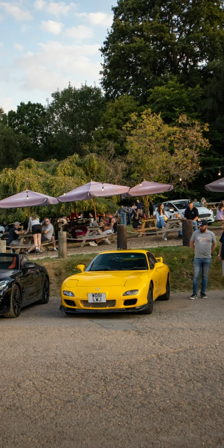 a yellow sports car parked in the dirt