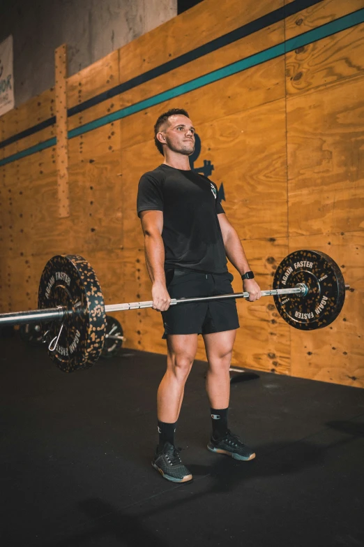 a man holds on to a barbell in a gym