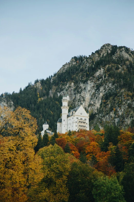 a large house sitting on top of a mountain near trees