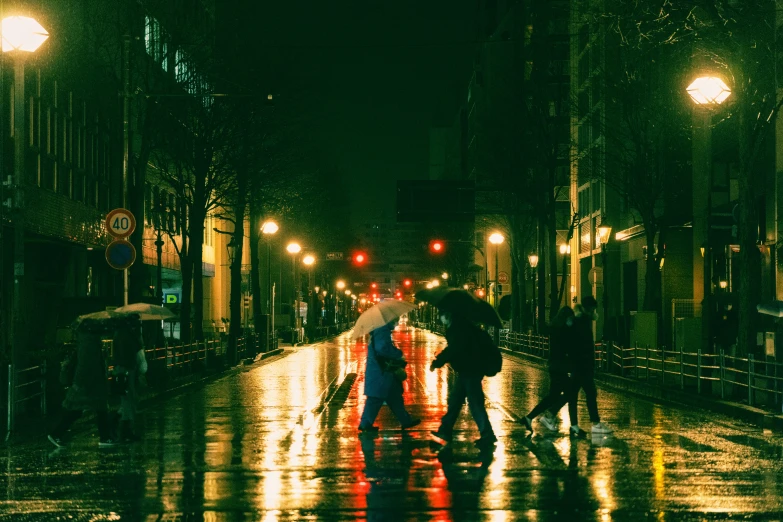 people crossing the street in the rain while holding an umbrella