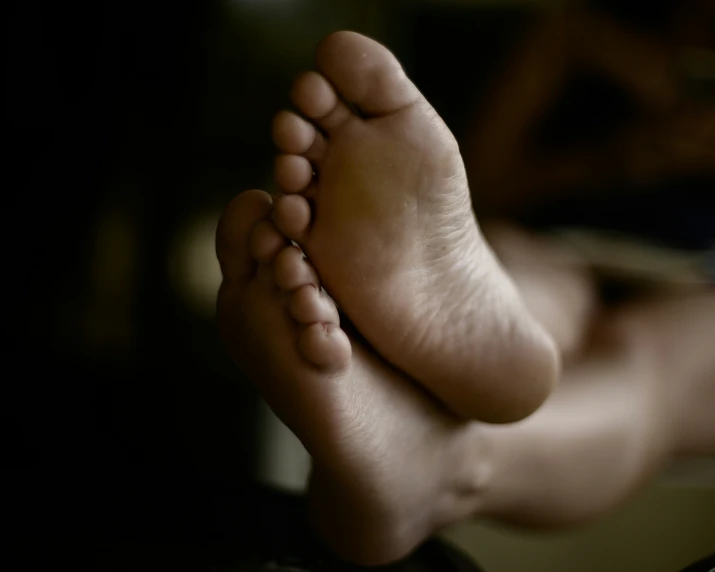 a bare foot laying on top of a bed