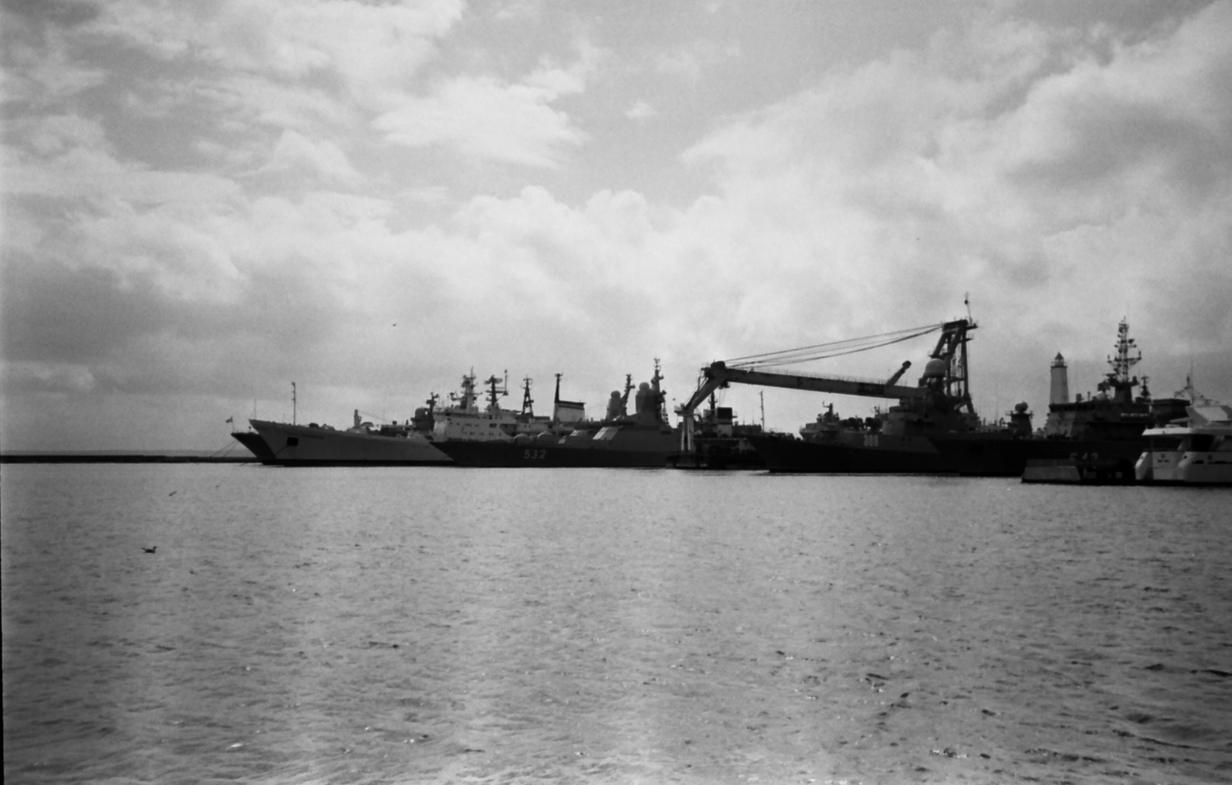 a very large and small ship sitting by the dock