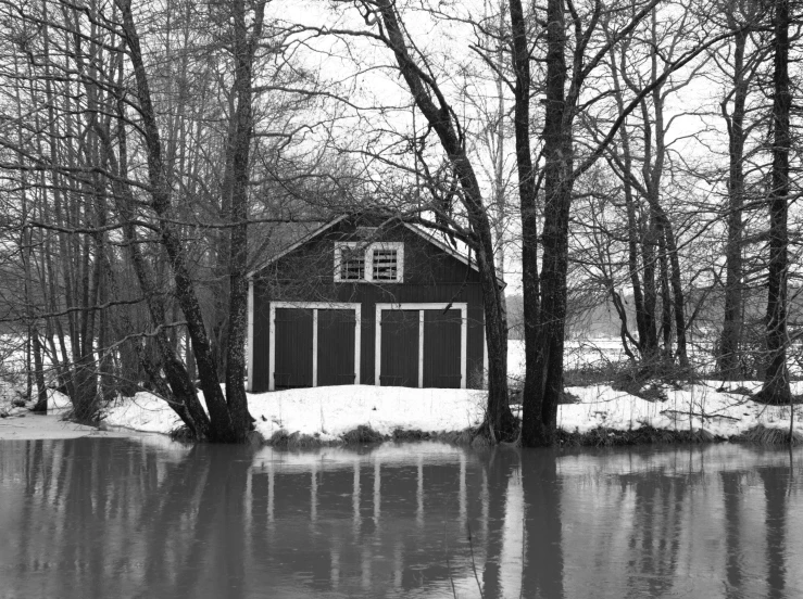 black and white pograph of flooded water in front of a barn