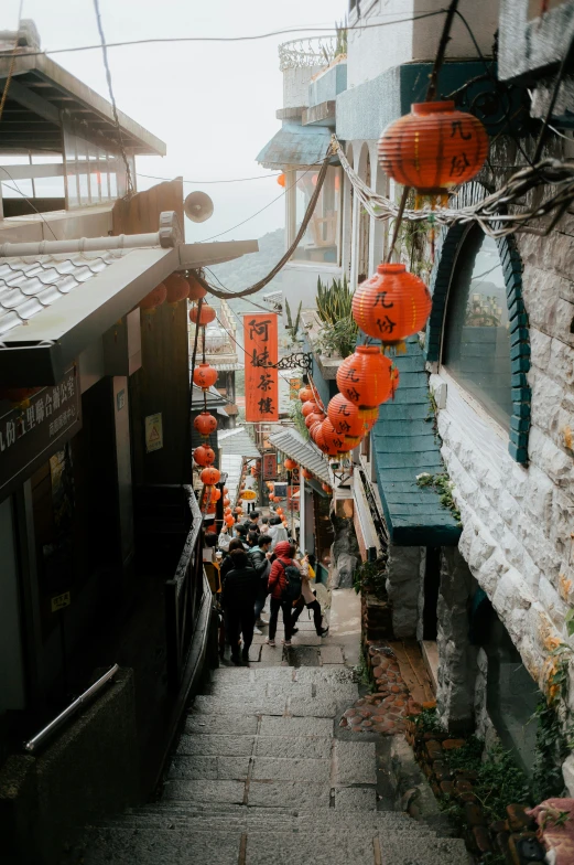 an alley filled with lots of people walking up to buildings