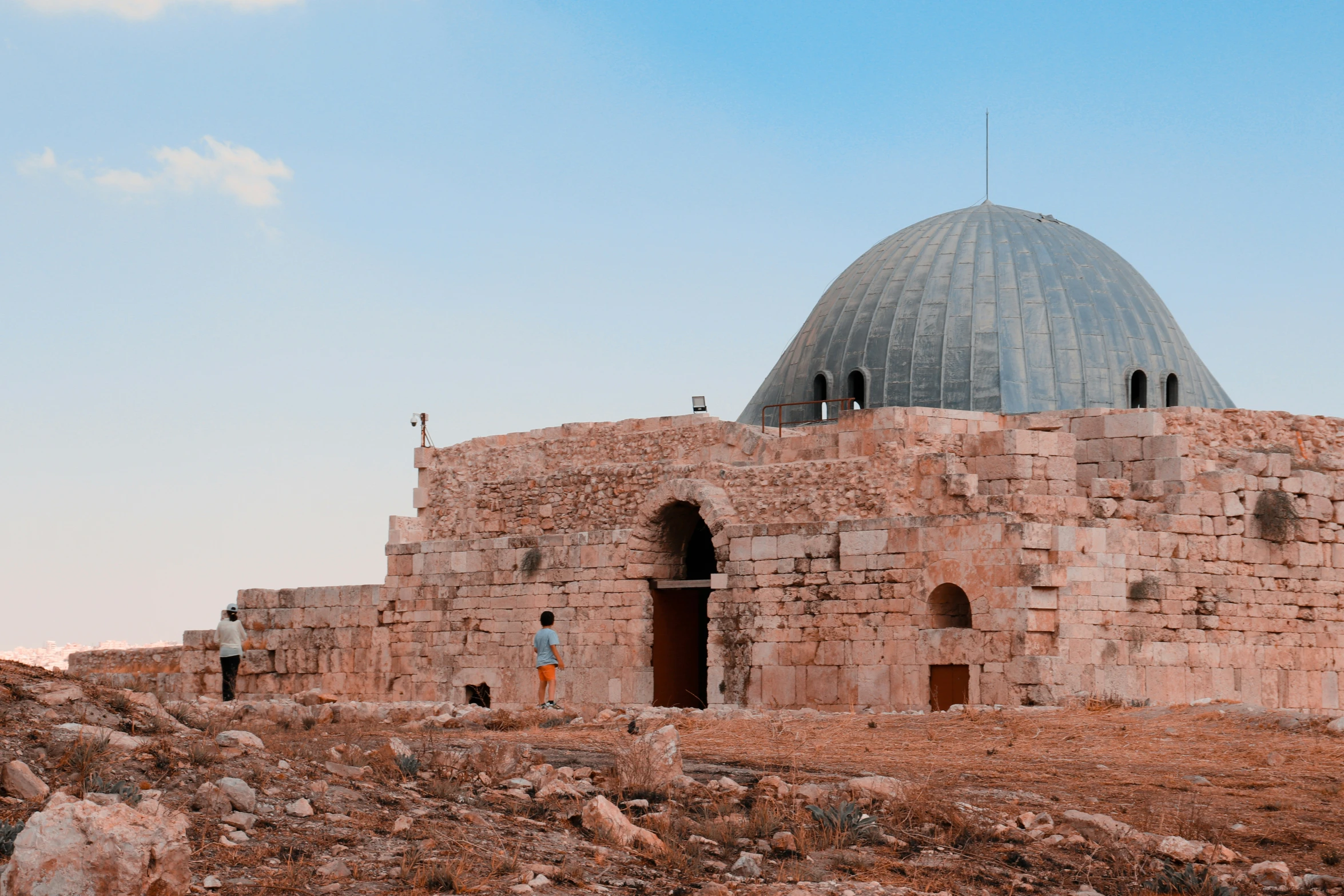 the man is walking up to the stone structure