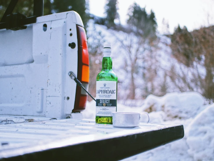 a beer bottle sitting on the back of a white truck