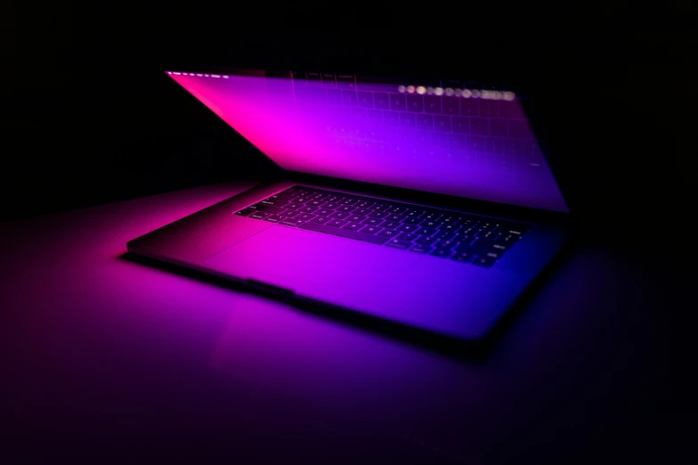 two laptops sitting side by side on a table