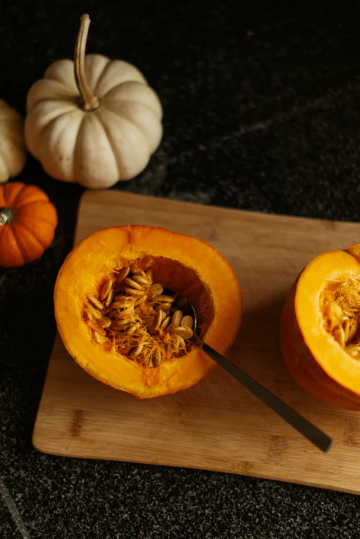 two pumpkin halves sitting on top of a  board