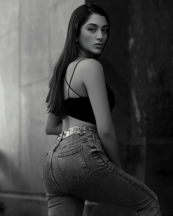 a girl standing next to a wall with her back turned