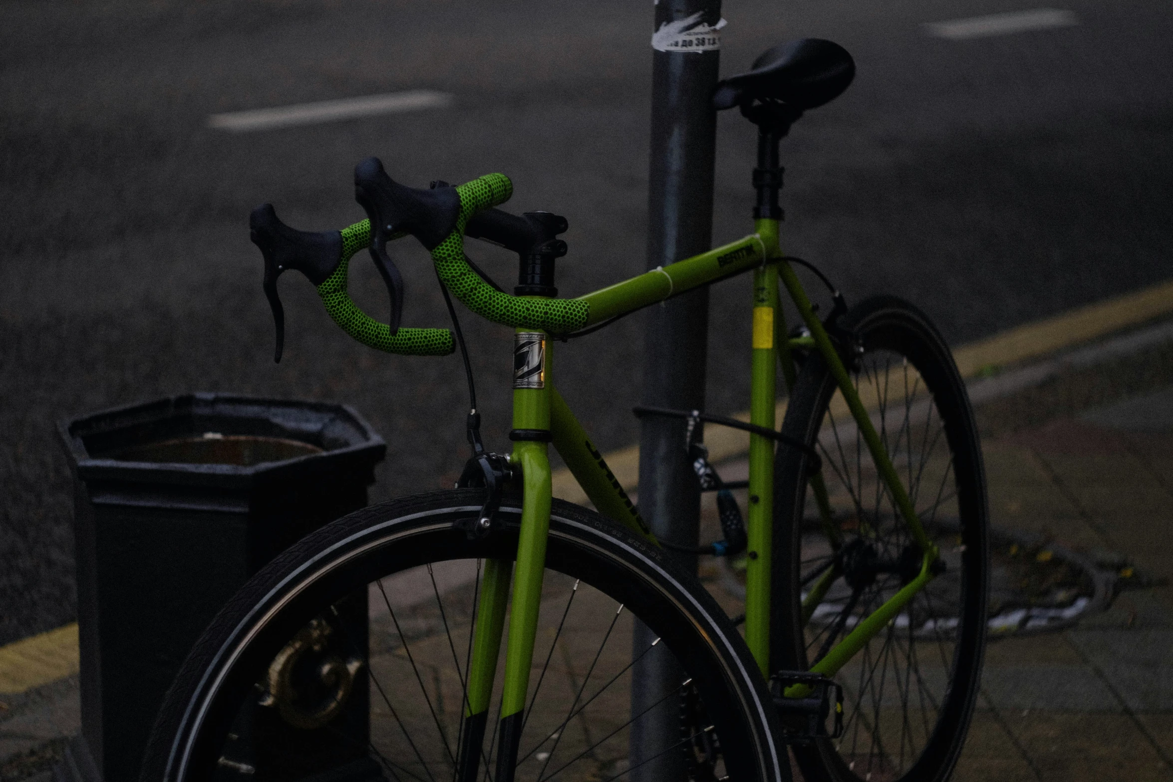 a bike parked next to a pole and street