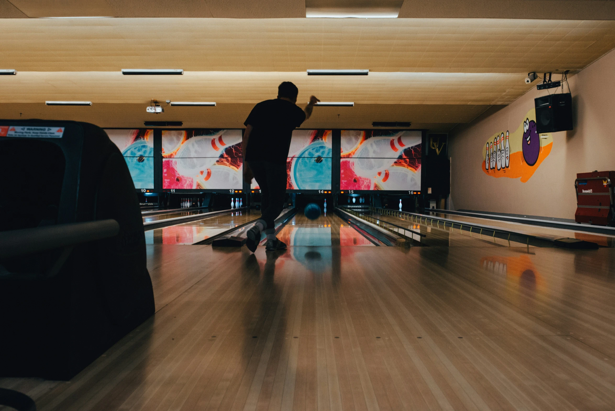 a man is throwing a bowling ball on a roller