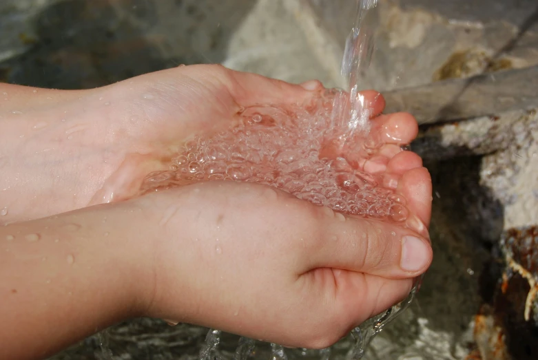 child hand with soap rinse on small waterfall