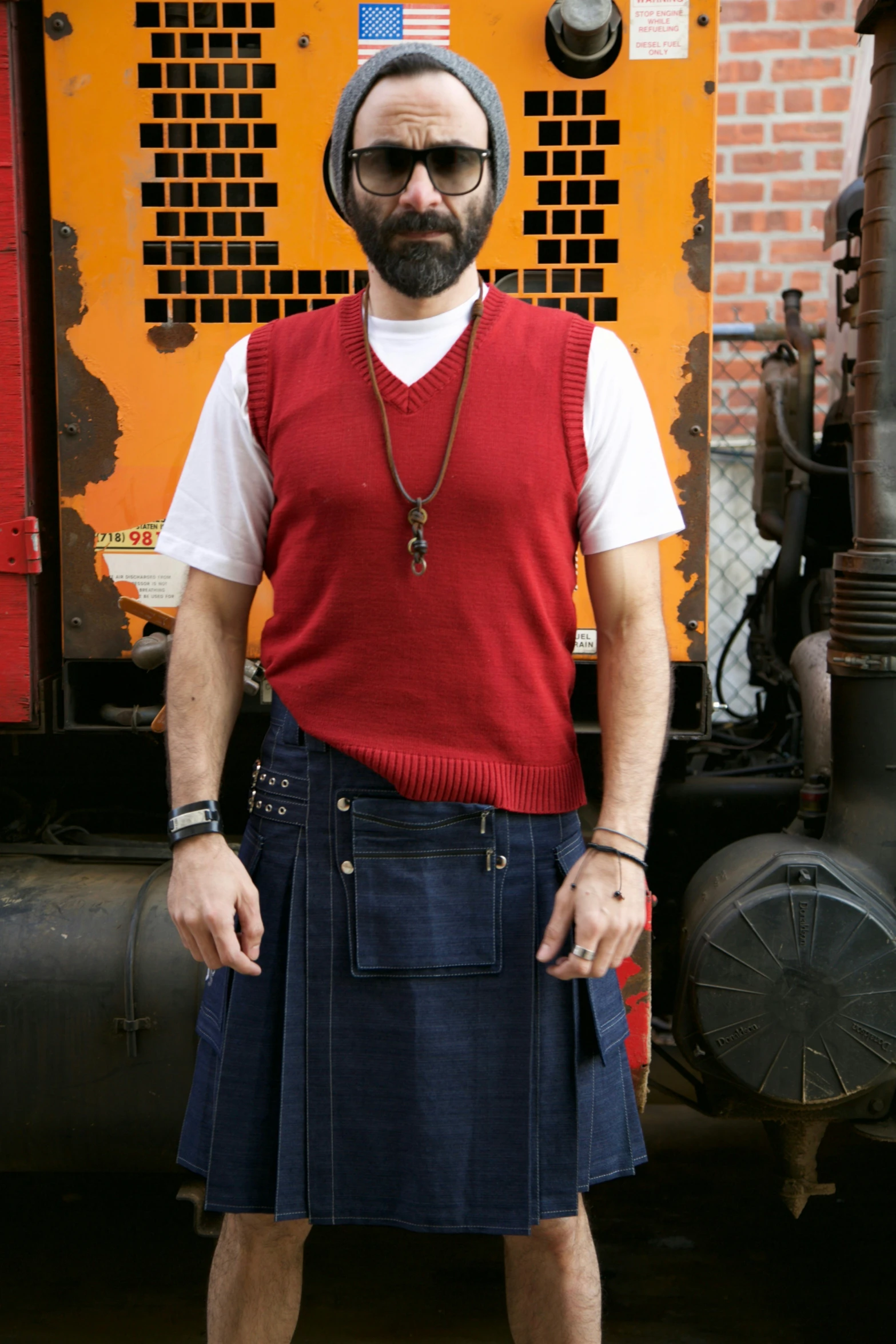 a man in red sweater vest and blue skirt