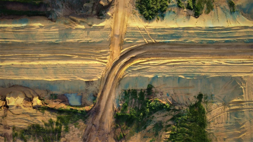 an aerial view of the road between some trees and cliff sides