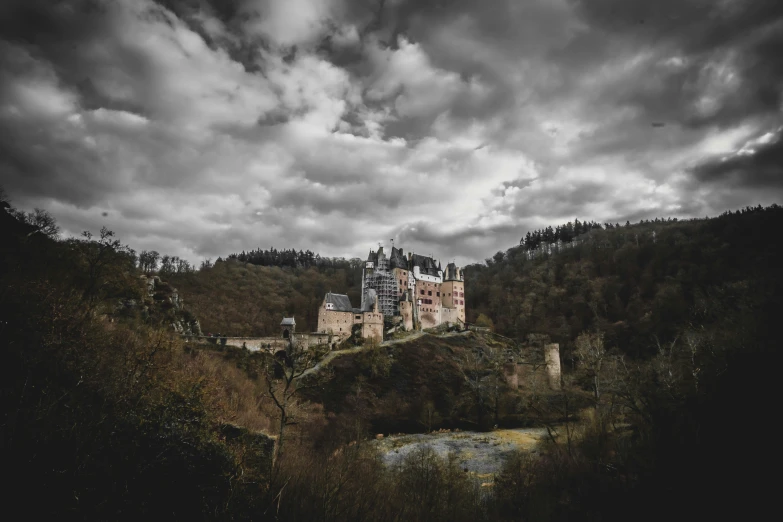 a castle on top of a hill under clouds