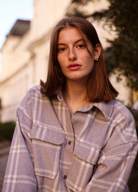 a woman in a checkered shirt with her arms crossed