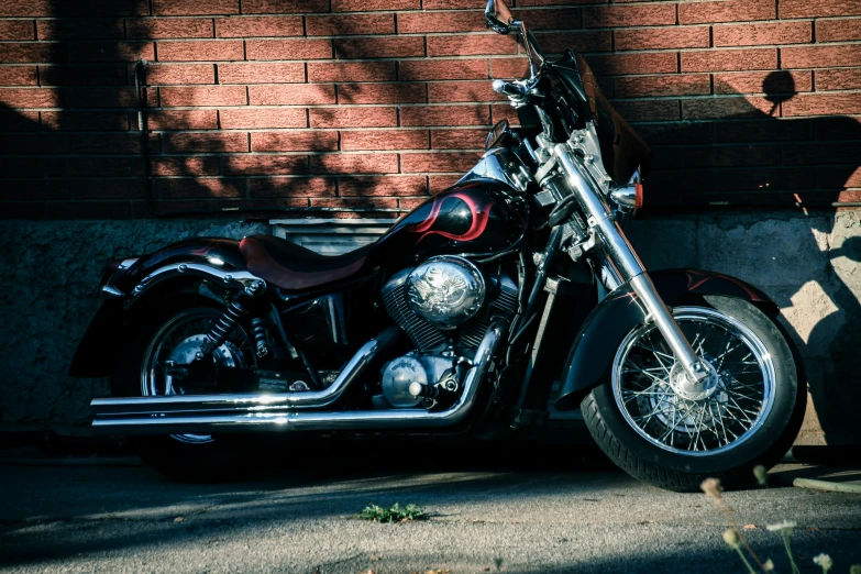 a red motorcycle parked by a brick building