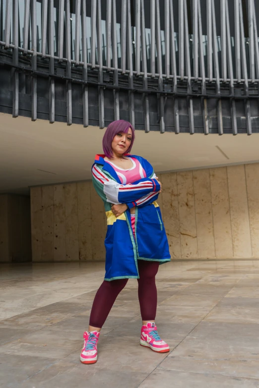 young woman in a blue and red outfit poses for the camera