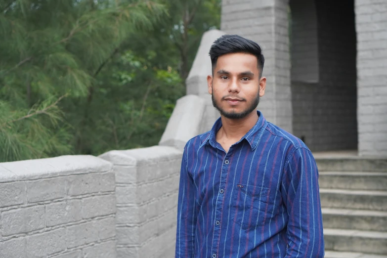 a man in a striped shirt standing next to some steps