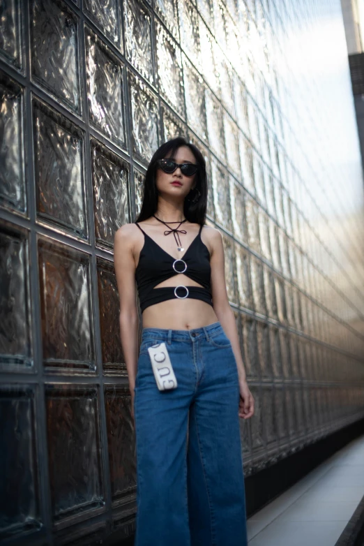 a woman standing next to a brick wall