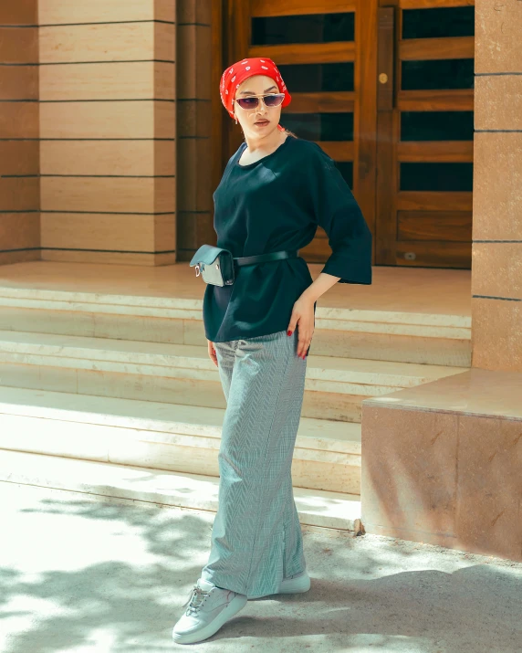 a woman is standing near stairs with sunglasses on