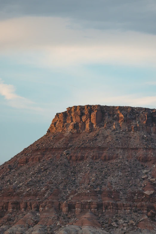 a brown rock face is in the distance with a cloudy sky above