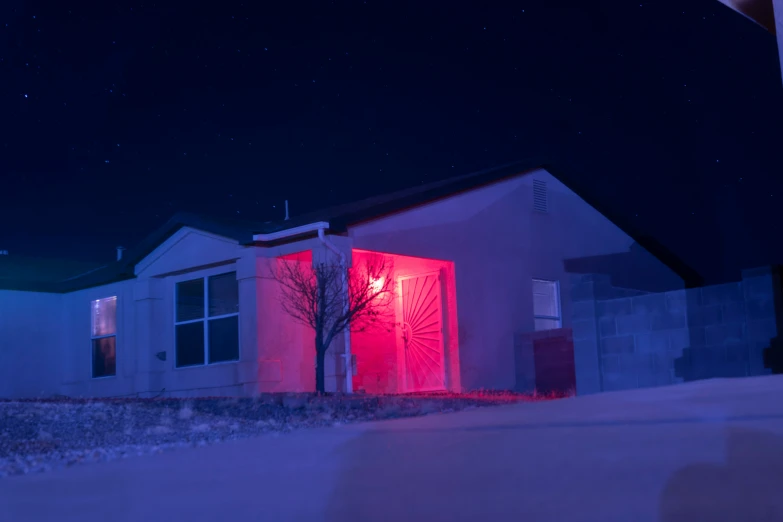 the exterior of a house with red lighting on