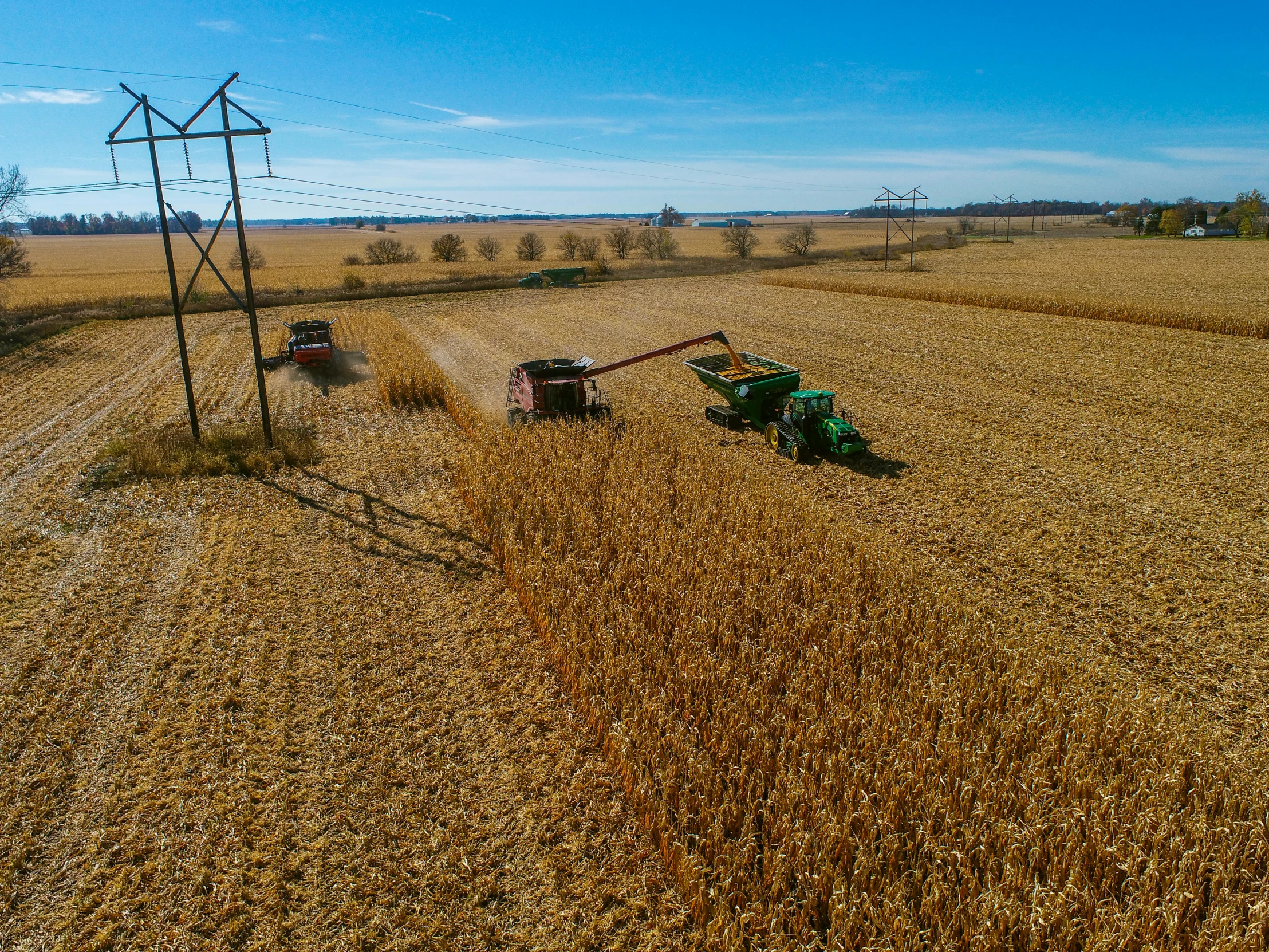 two farm vehicles parked in the middle of a field