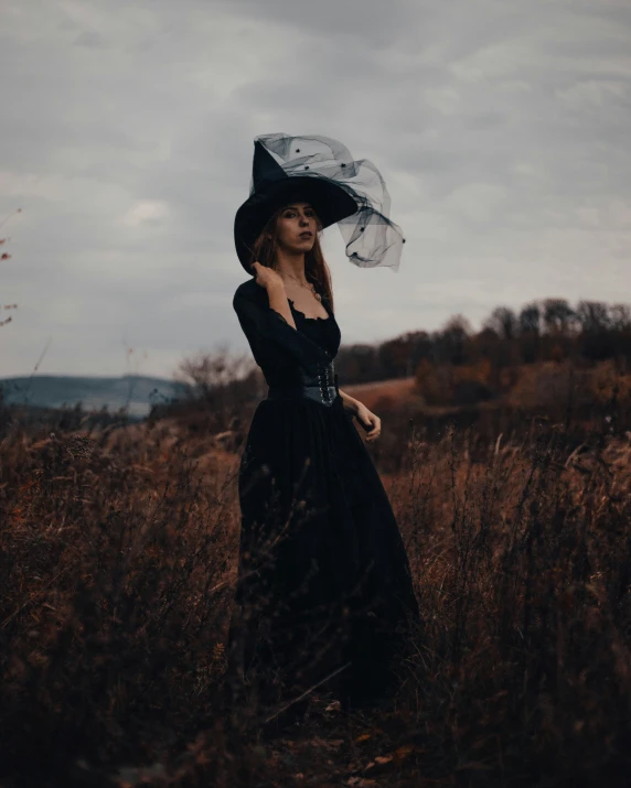 a woman in a black dress and hat