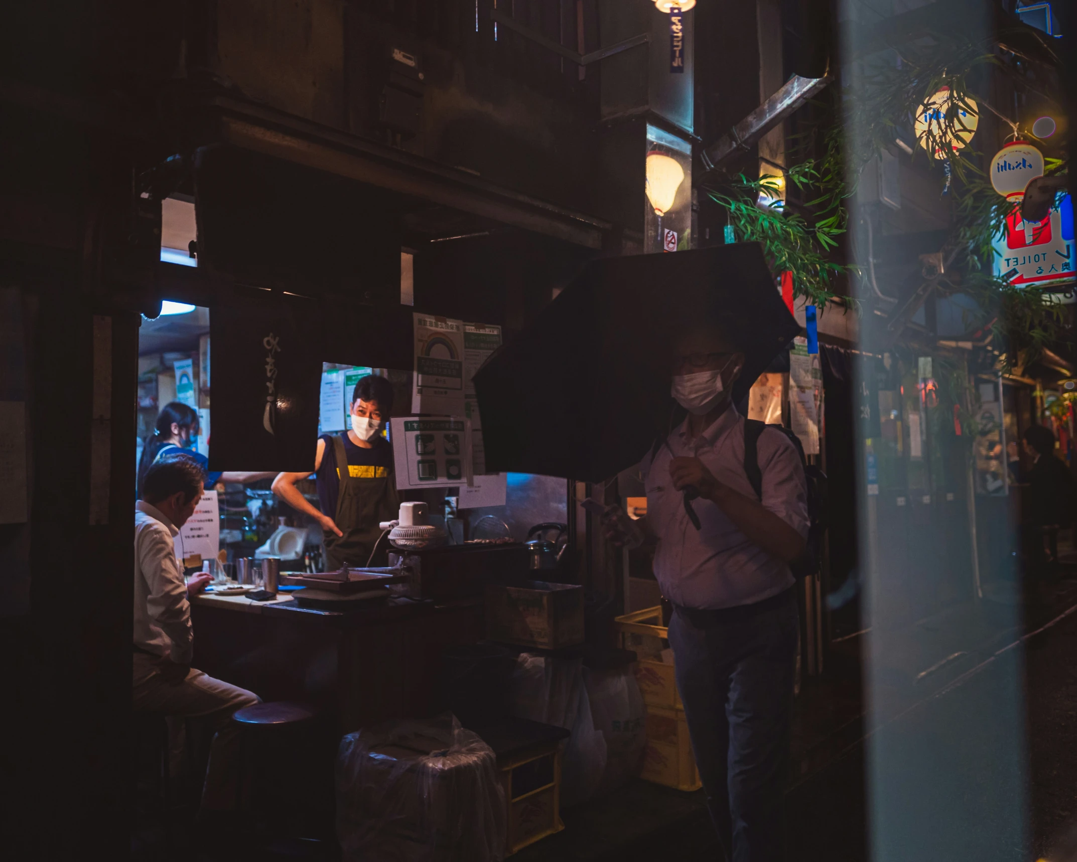 a man standing next to a bar in the dark