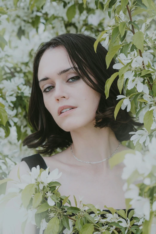 a young woman in black shirt hiding in trees