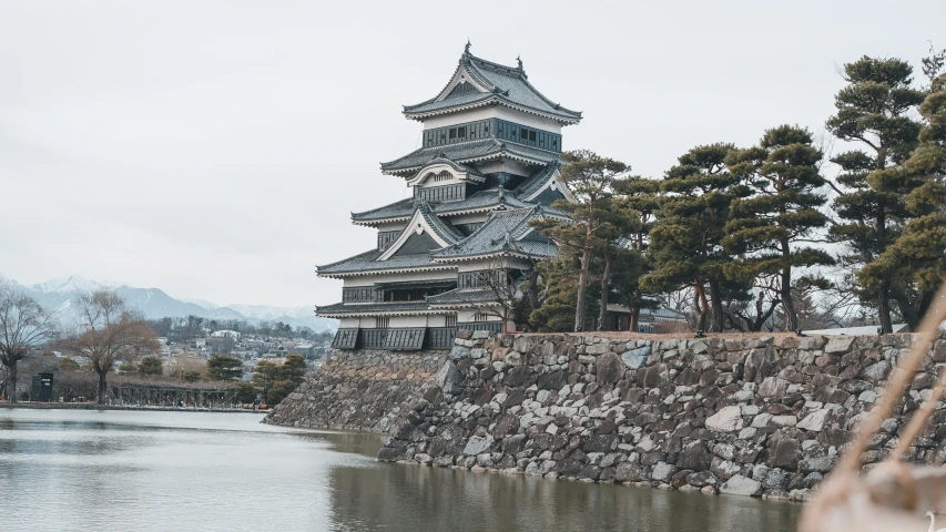 the castle sits by the water near the mountains