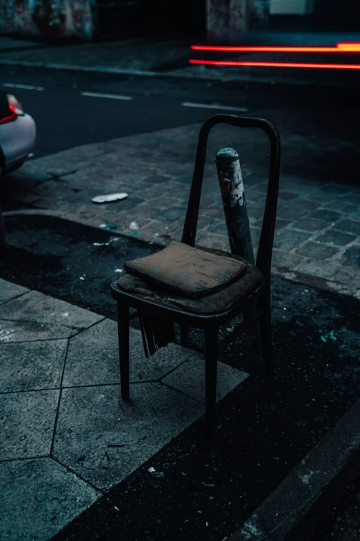 an old chair sitting on a curb next to a street
