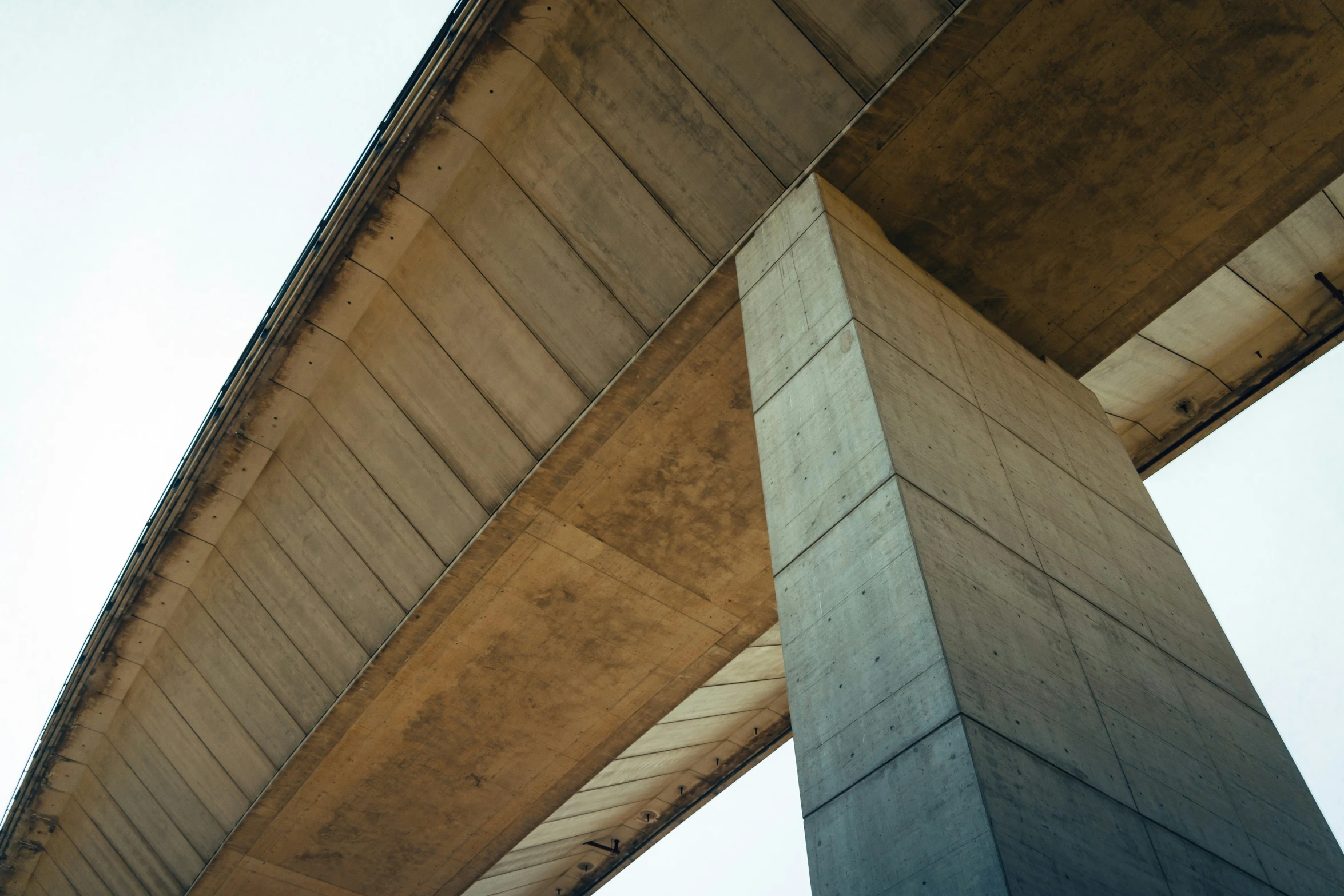 a bridge looking up with concrete pillars on it