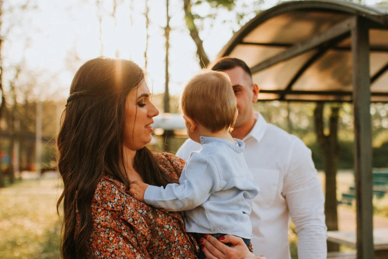 a couple and their son are standing together while holding each other in their arms