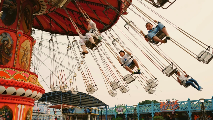 two people jumping from the top of a carnival ride