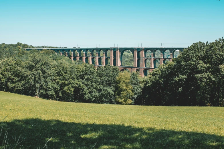 view of a long bridge from near a grassy field