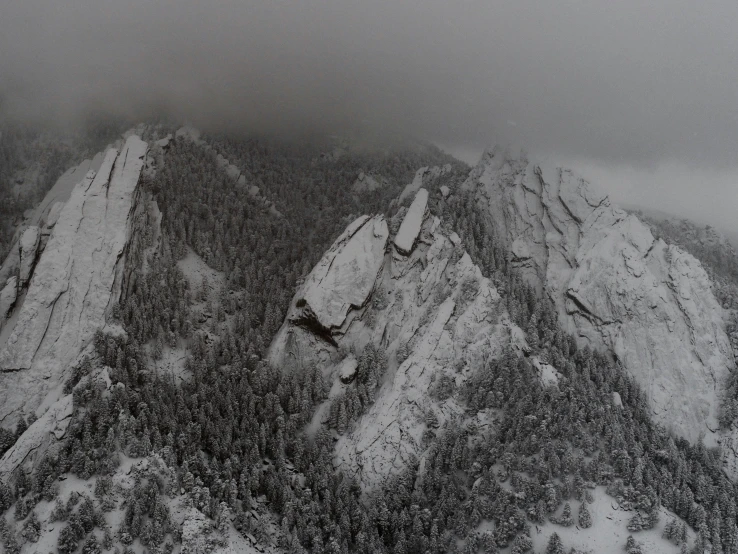 a cloudy view of some very tall mountains covered in snow