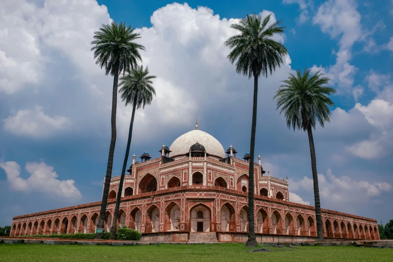 two palm trees stand in the foreground in front of a domed structure