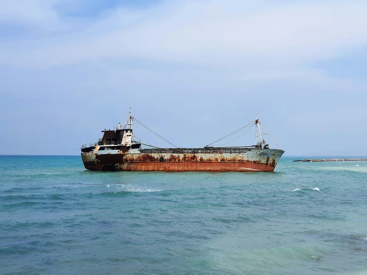 an old boat in the ocean with waves