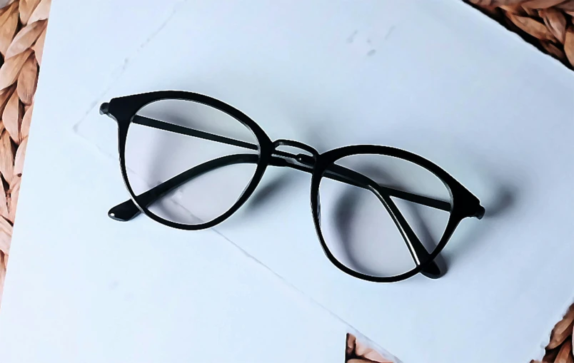 some black glasses are laying on top of a book