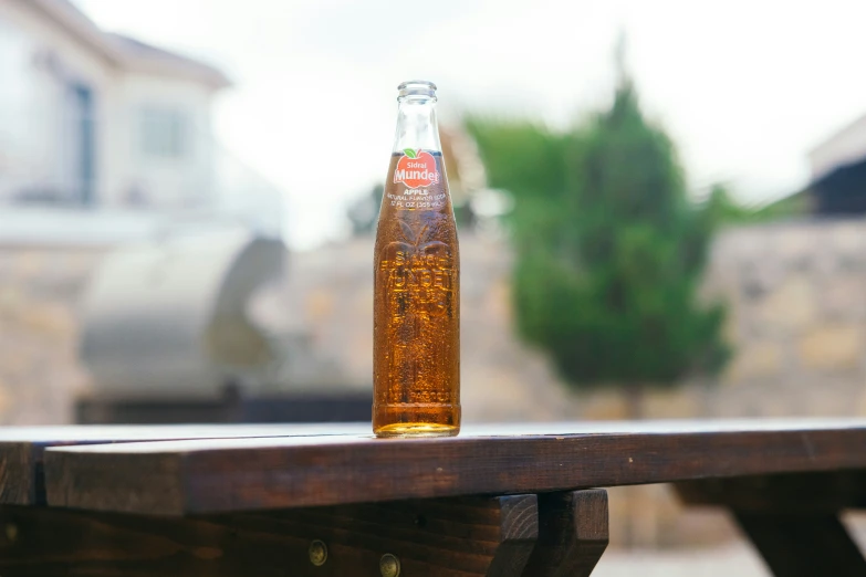 an unopened bottle on a wooden bench