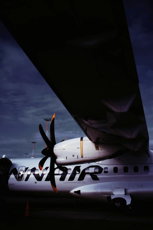 the side view of an airplane at night with clouds in the sky